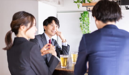 カフェで会話する3人のビジネスパーソン